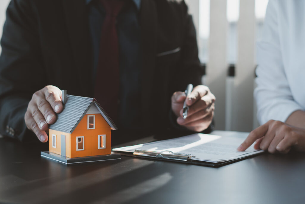 Real estate sector, agent and buyers shaking hands over signed documents